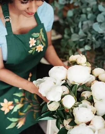 Florist arranging white peony flowers in a shop